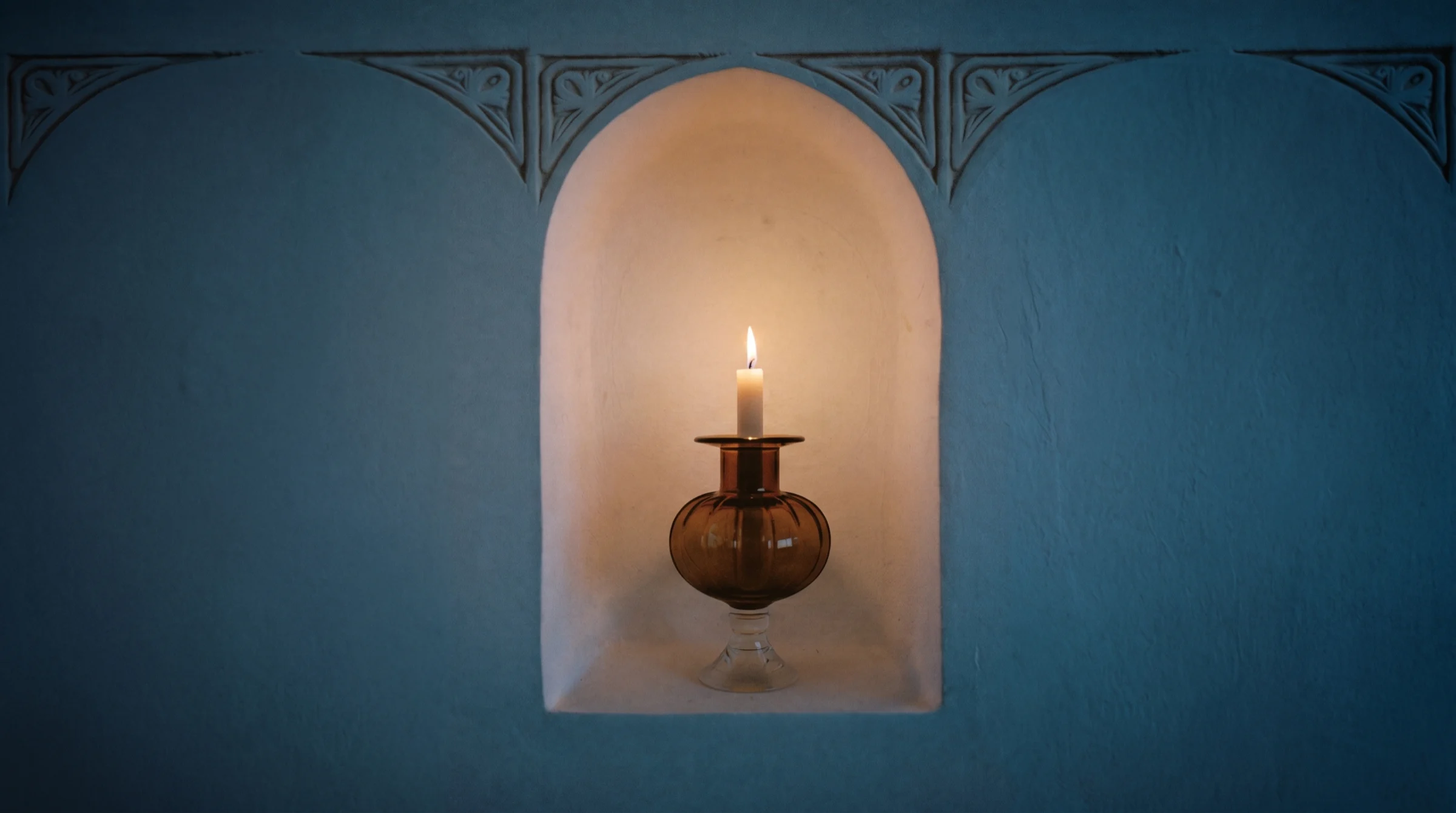 Candle in a plaster arch niche